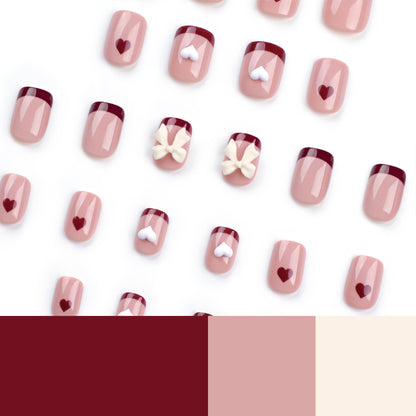 Kunstvolle Nagelkunst mit Herz- und Schleifenmotiven Brehn