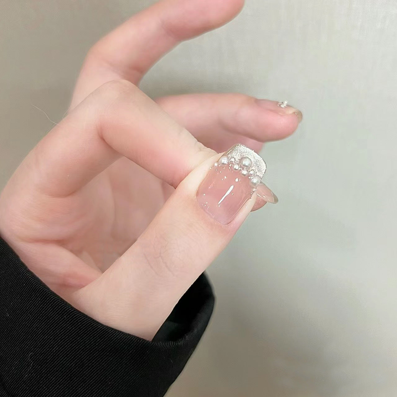 Elegante Kunstnägel mit Perlenschmuck und Glitzereffekten Brehn