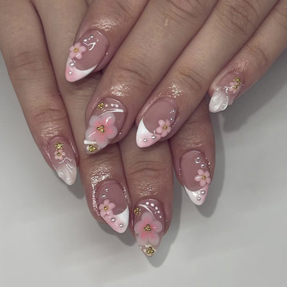 Kunstvolle Nagelverlängerungen mit Blütenmuster und Glitzerakzenten Brehn