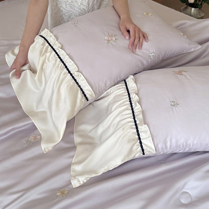 Exquisites Satin-Bettwäscheset mit floraler Stickerei, gerafften Kissenblenden und kontrastierender Paspel