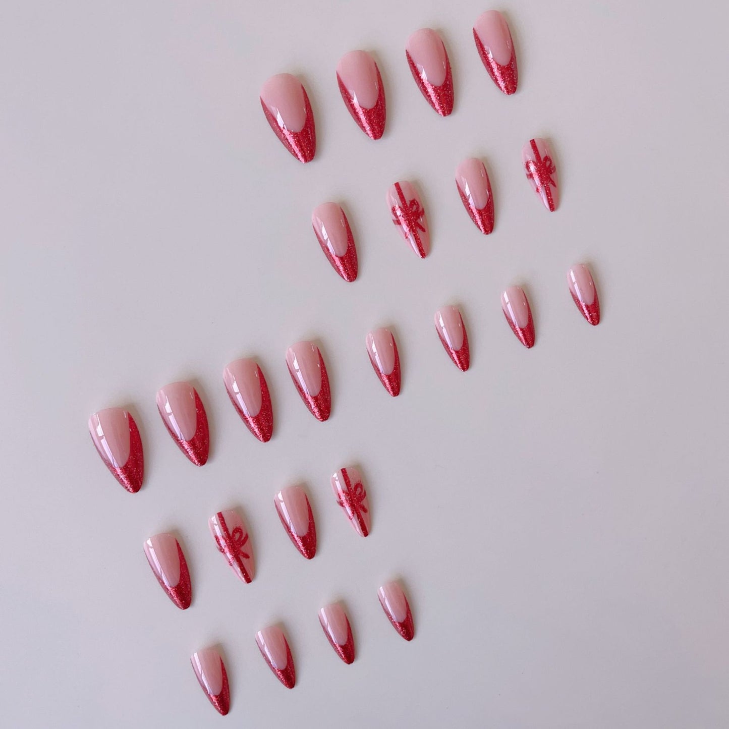 Kunstnagelset mit glamourösen Glitzer-Akzenten und Schleifen-Design Brehn