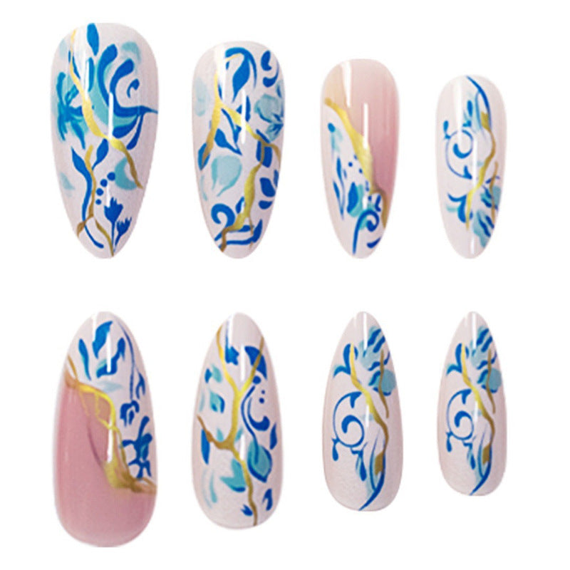 Künstlerisches florales Press-On-Nageldesign mit goldenen Akzenten Brehn