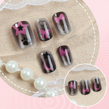 Künstlerisches Press-On Nagelset mit Stern- und Schleifenmotiven
