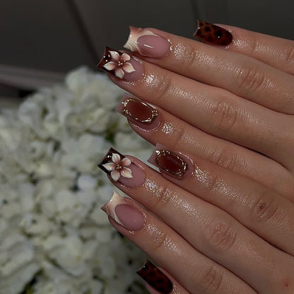 Kunstvolle Stiletto-Nägel mit eleganten Floraldesign und Glitzereffekten Brehn