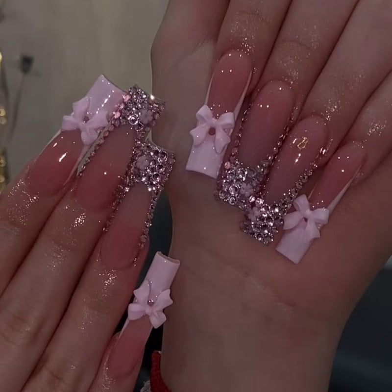 Kunstvolle Nagelkunst mit Strassverzierungen und Schleifen Brehn