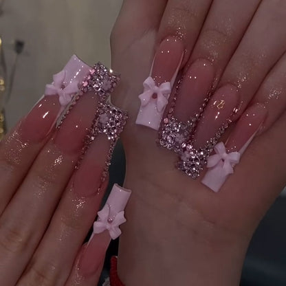 Kunstvolle Nagelkunst mit Strassverzierungen und Schleifen Brehn