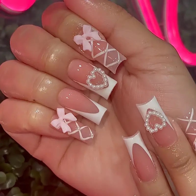 Elegante Kunstnagelspitzen mit Herz- und Schleifenakzenten Brehn
