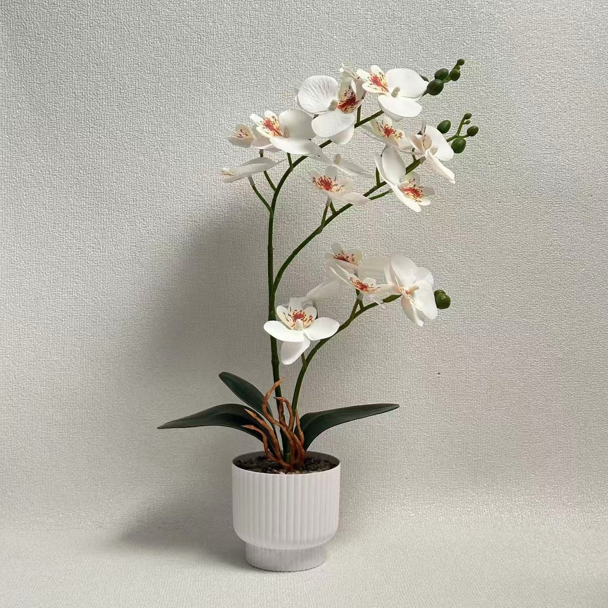 Realistische künstliche Orchideenpflanze mit dekorativem Topf