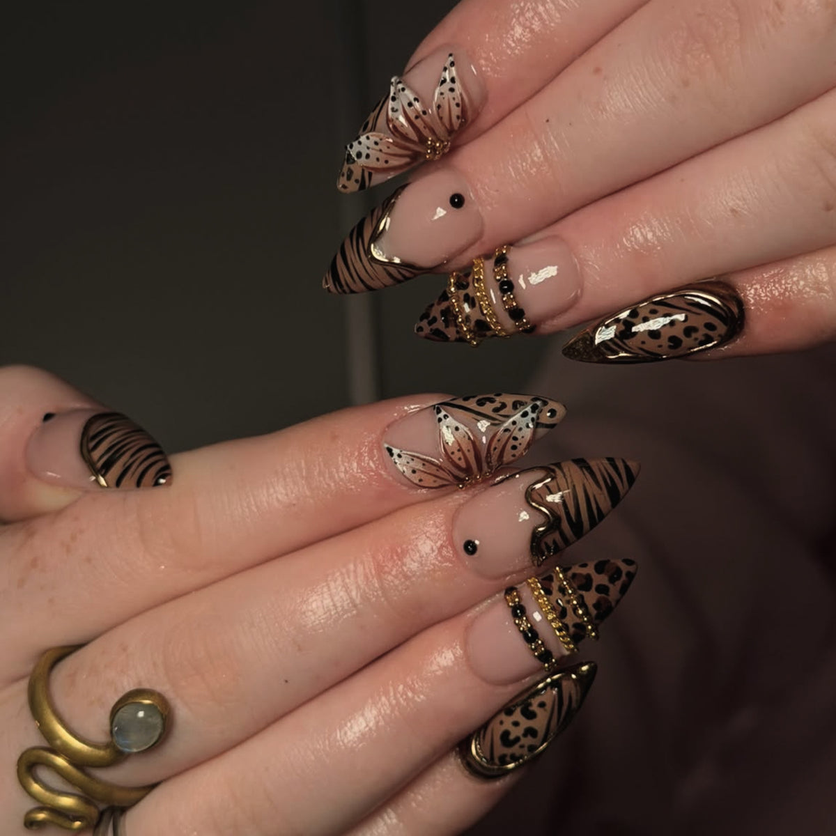 Kunstvoller Stiletto-Nagel mit floralen Akzenten und Goldverzierungen Brehn