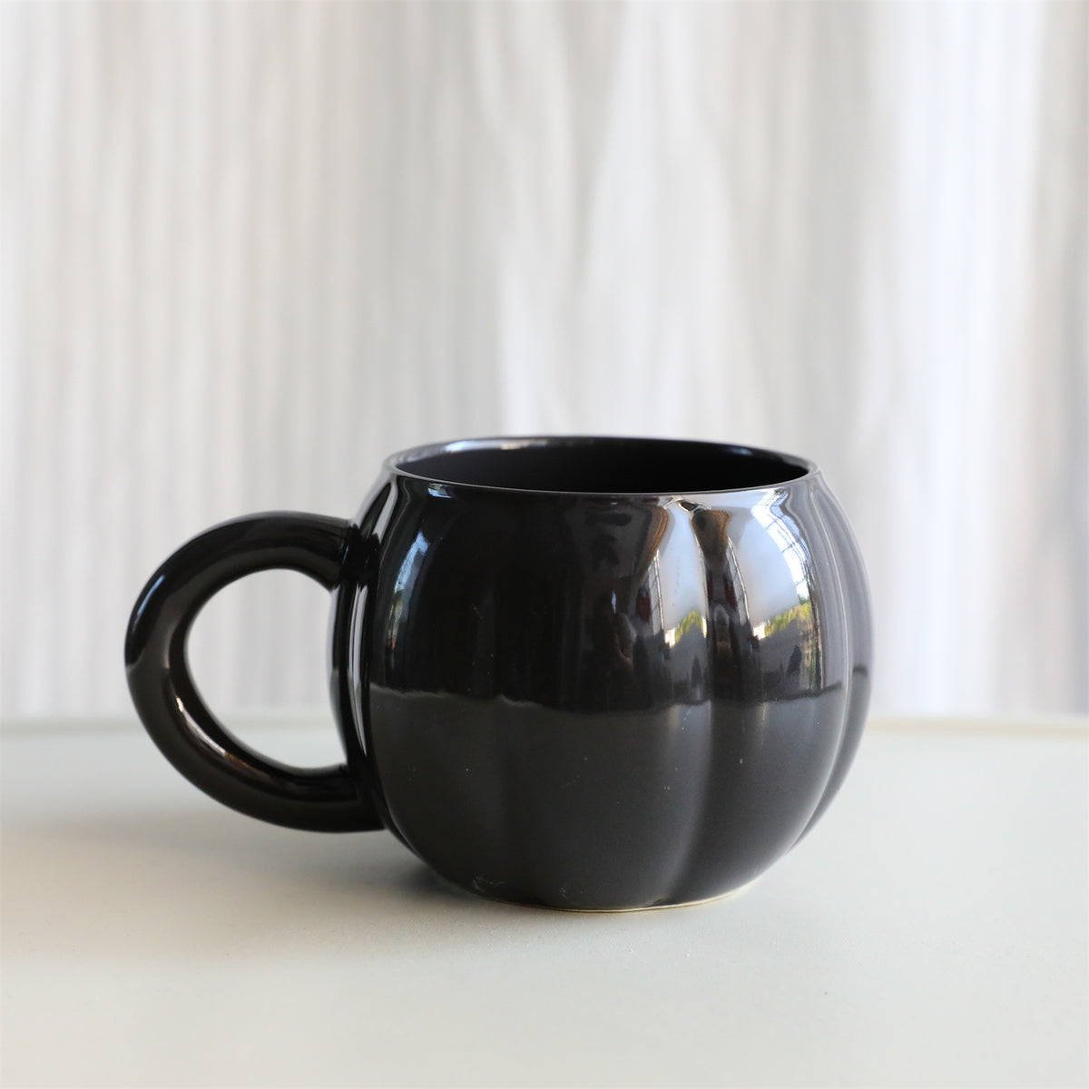 Keramikbecher mit ergonomischem Griff und geriffelter Ballonform