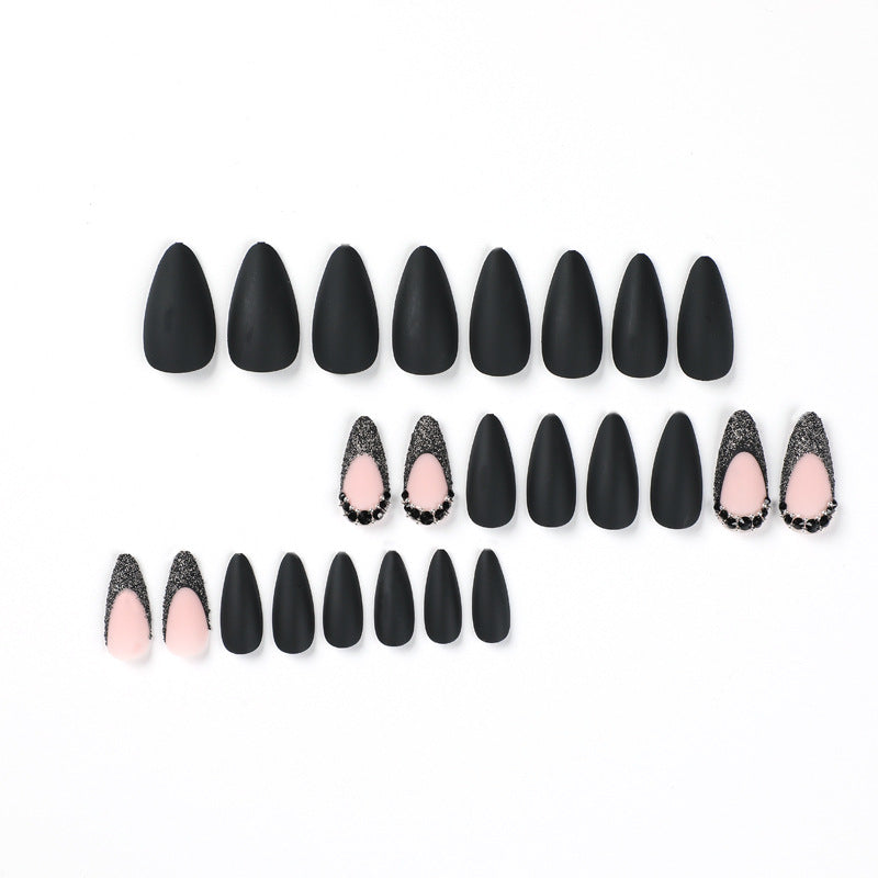 Kunstvolle Stiletto-Nägel mit elegantem Schwarz-Design und Glitzerakzenten Brehn