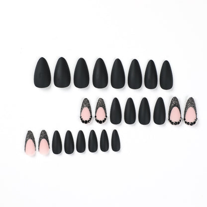 Kunstvolle Stiletto-Nägel mit elegantem Schwarz-Design und Glitzerakzenten Brehn