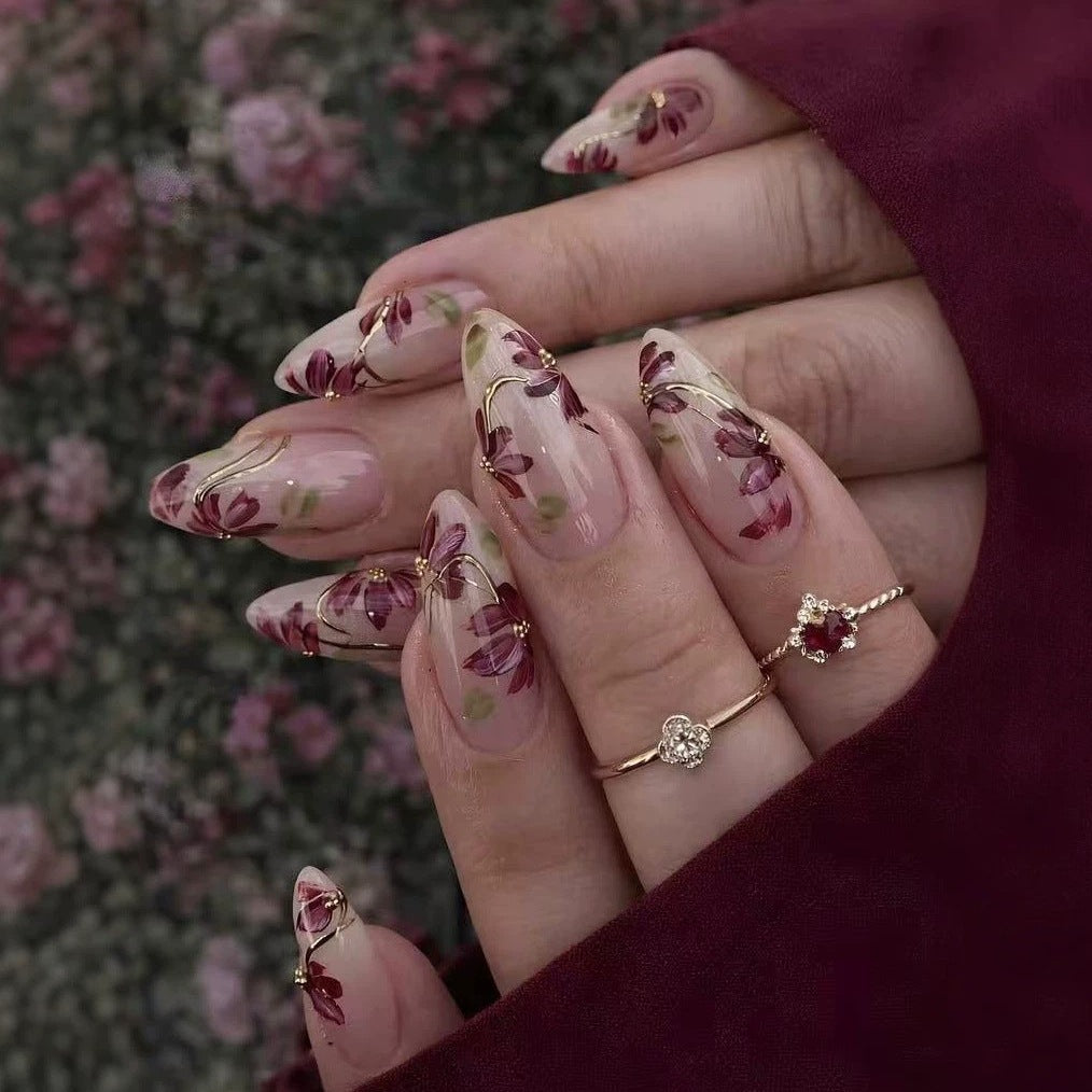 Kunstnagelset mit floralen Mustern und goldenen Akzenten Brehn