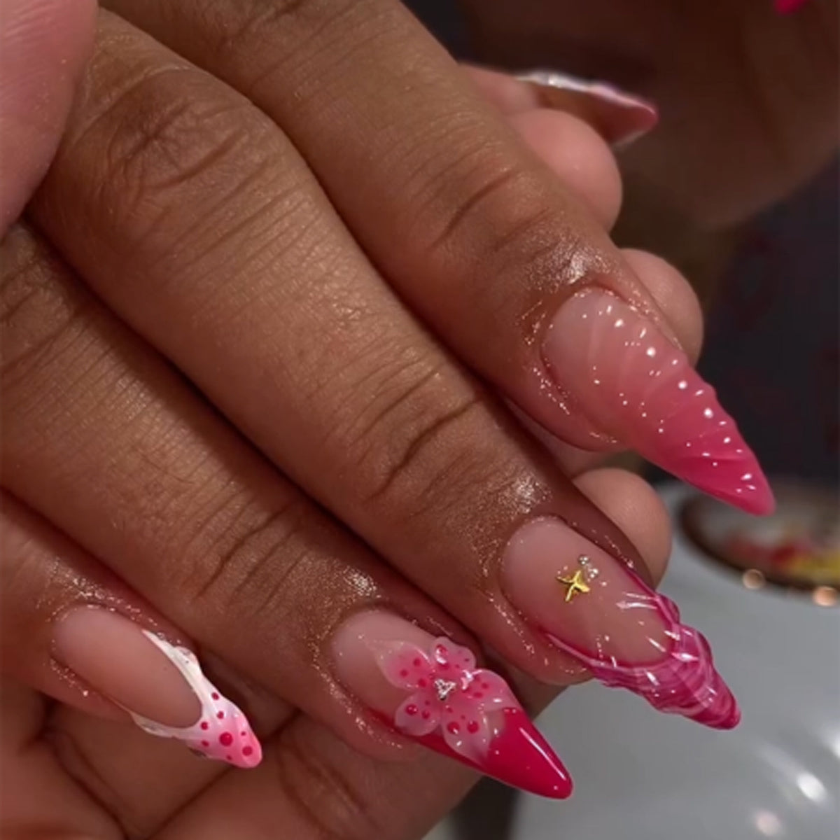 Kunstvolle Stiletto-Nägel mit floralem Design und Glitzerakzenten Brehn