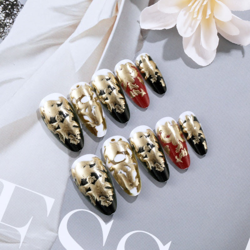 Elegante Kunstnägel mit Gold- und Schwarzmuster Brehn