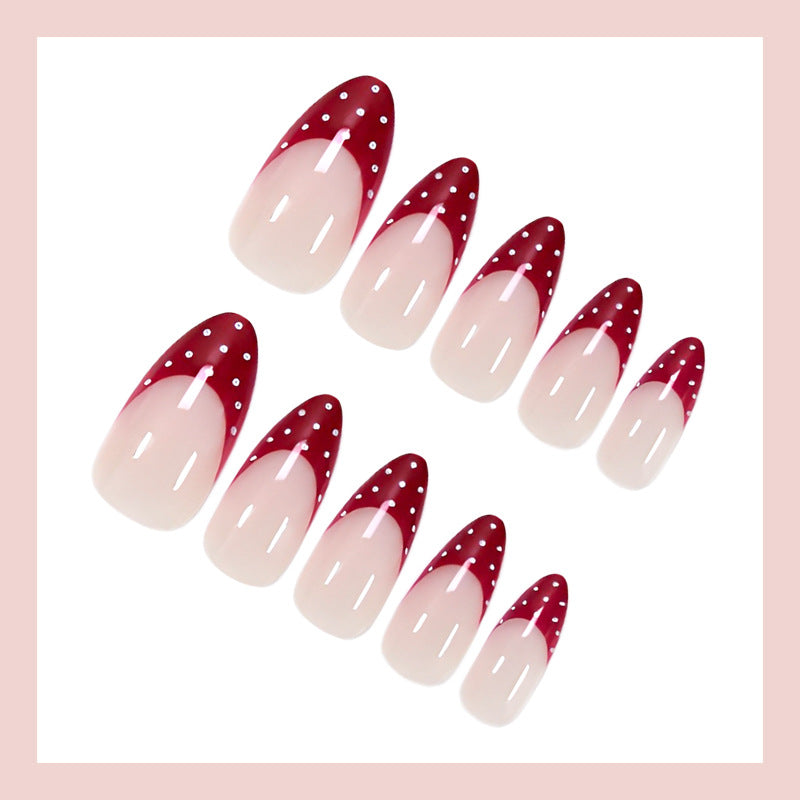 Kunstnagelset mit eleganten roten Spitzen und verspielten Punkten Brehn