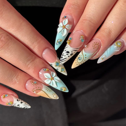 Kunstvolle Stiletto-Nägel mit floralen Akzenten und Glitzerdetails Brehn
