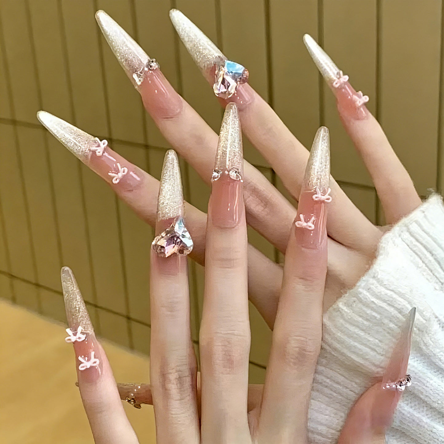 Kunstnagelset mit funkelnden Spitzen und zarten Schleifenverzierungen Brehn