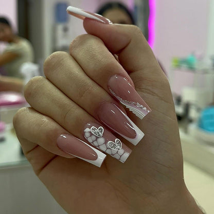 Kunstvolle Nagelverlängerungen mit Herzdesign und Glitzerakzenten Brehn