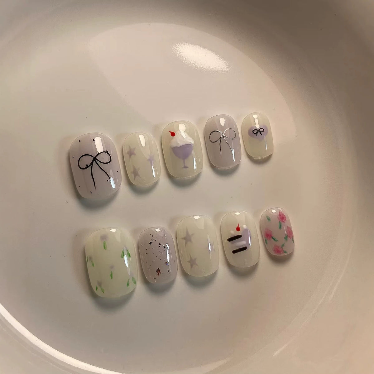Künstlerisches Press-On Nagelkunstkset mit niedlichen Kuchen- und Banddesigns