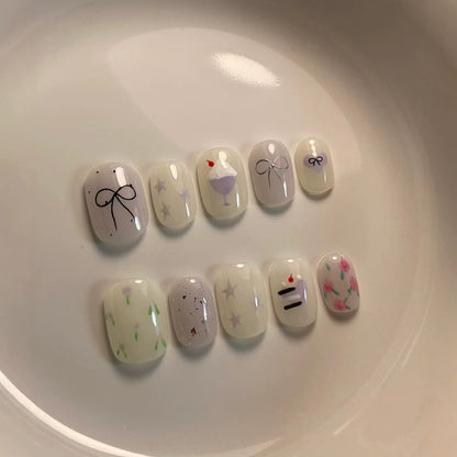 Künstlerisches Press-On Nagelkunstkset mit niedlichen Kuchen- und Banddesigns