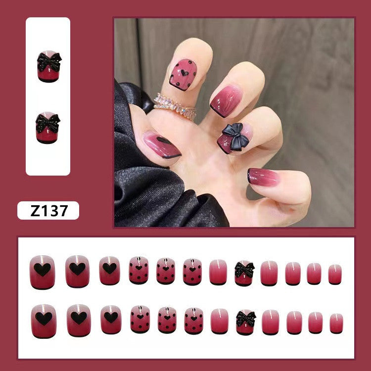 Themen Press-On Nagelset mit dekorativen Herz- und Schleifendesigns