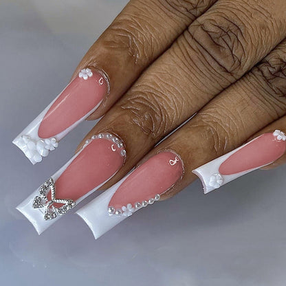 Kunstnagelset mit eleganten floralen Verzierungen und Glitzerakzenten Brehn