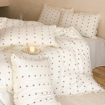 Gestepptes Bettwäscheset aus Baumwoll‑Musselin mit zartem Kirschenprint und Rüschenkante