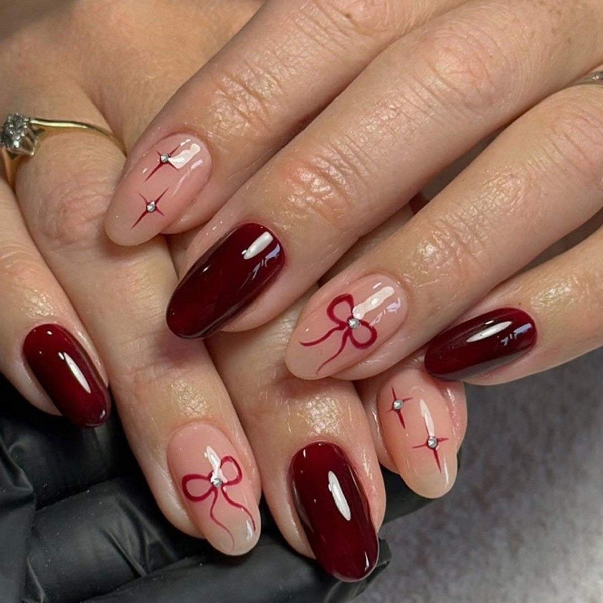 Kunstvolle Nagelkunst mit eleganten Schleifen und Strassverzierungen Brehn