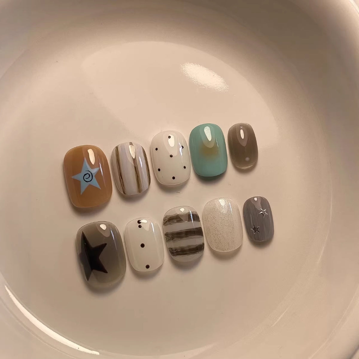 Künstlerisches Press-On Nagelset mit geometrischen und Stern-Designs