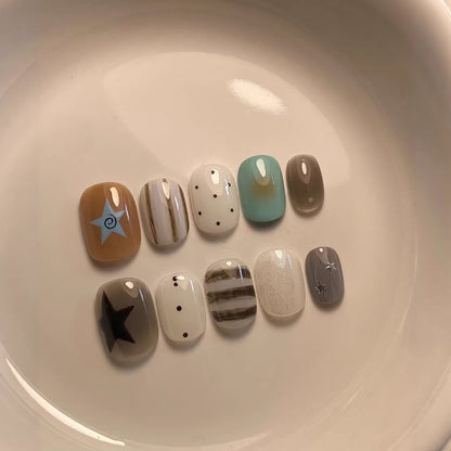 Künstlerisches Press-On Nagelset mit geometrischen und Stern-Designs