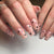 Kunstvolle Nagelkunst mit Herz-Design und Glitzerakzenten Brehn