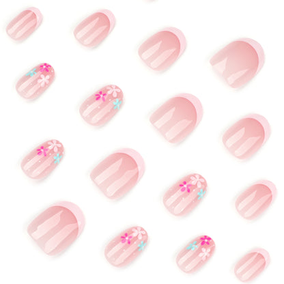 Kunstvolle Nagelverlängerungen mit bunten Blütenmotiven und Glitzer Brehn