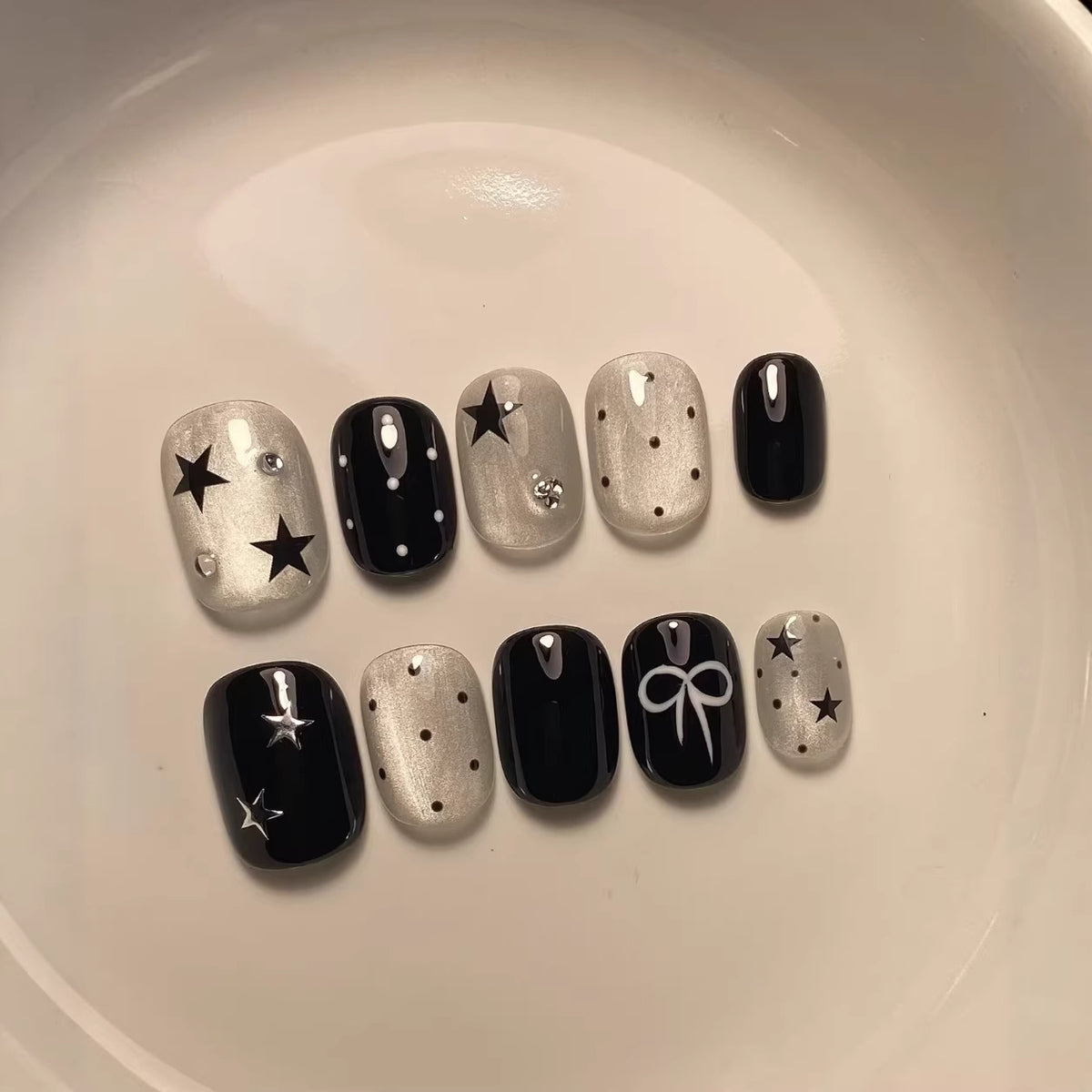 Künstlerisches Press-On-Nagelset mit Stern- und Bogenakzenten