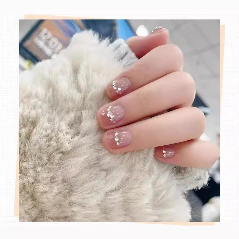 Kunstvolle Nagelkunst mit Schmetterlings- und Perlendetails Brehn