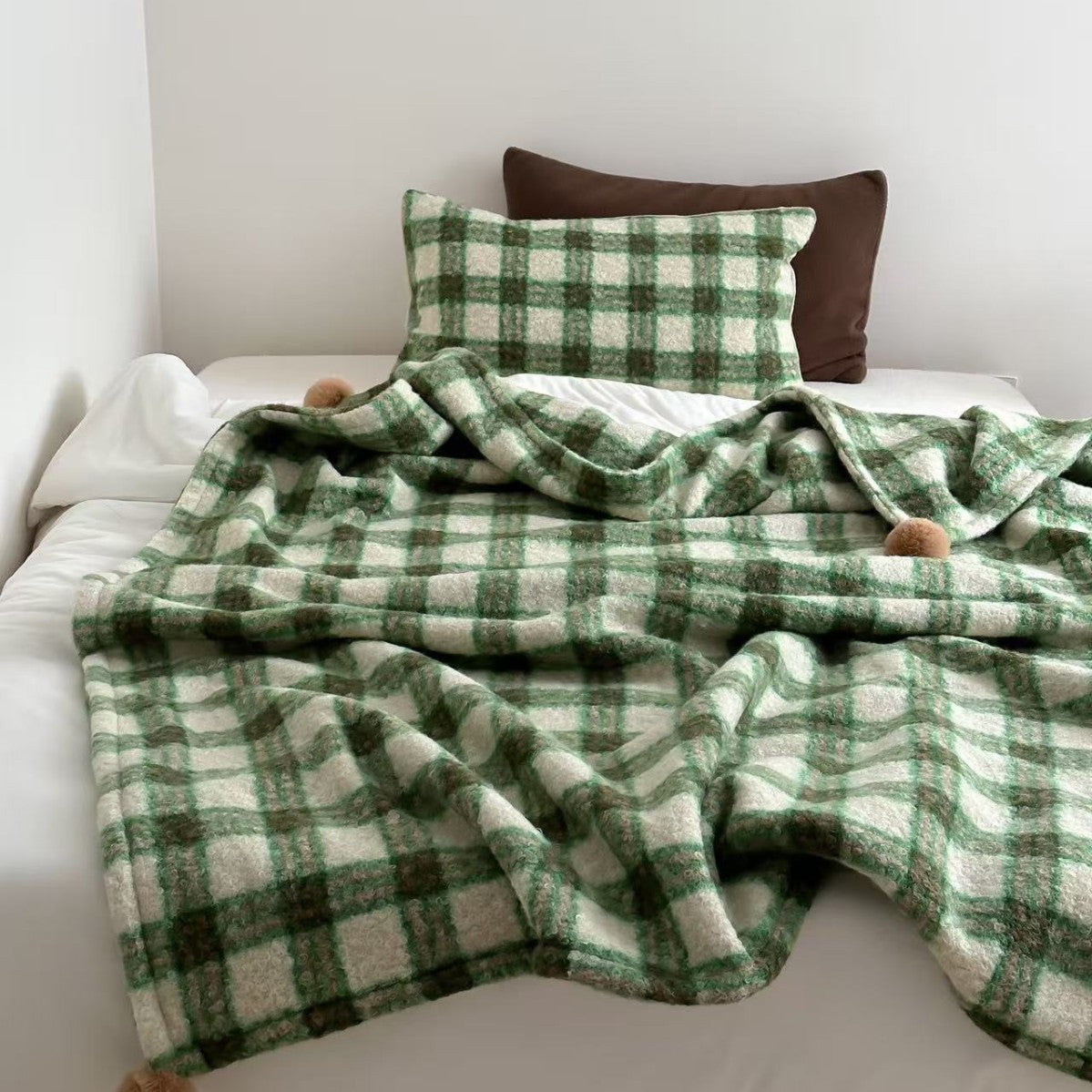 Kuscheldecke mit kariertem Muster und Bommelverzierung Brehn