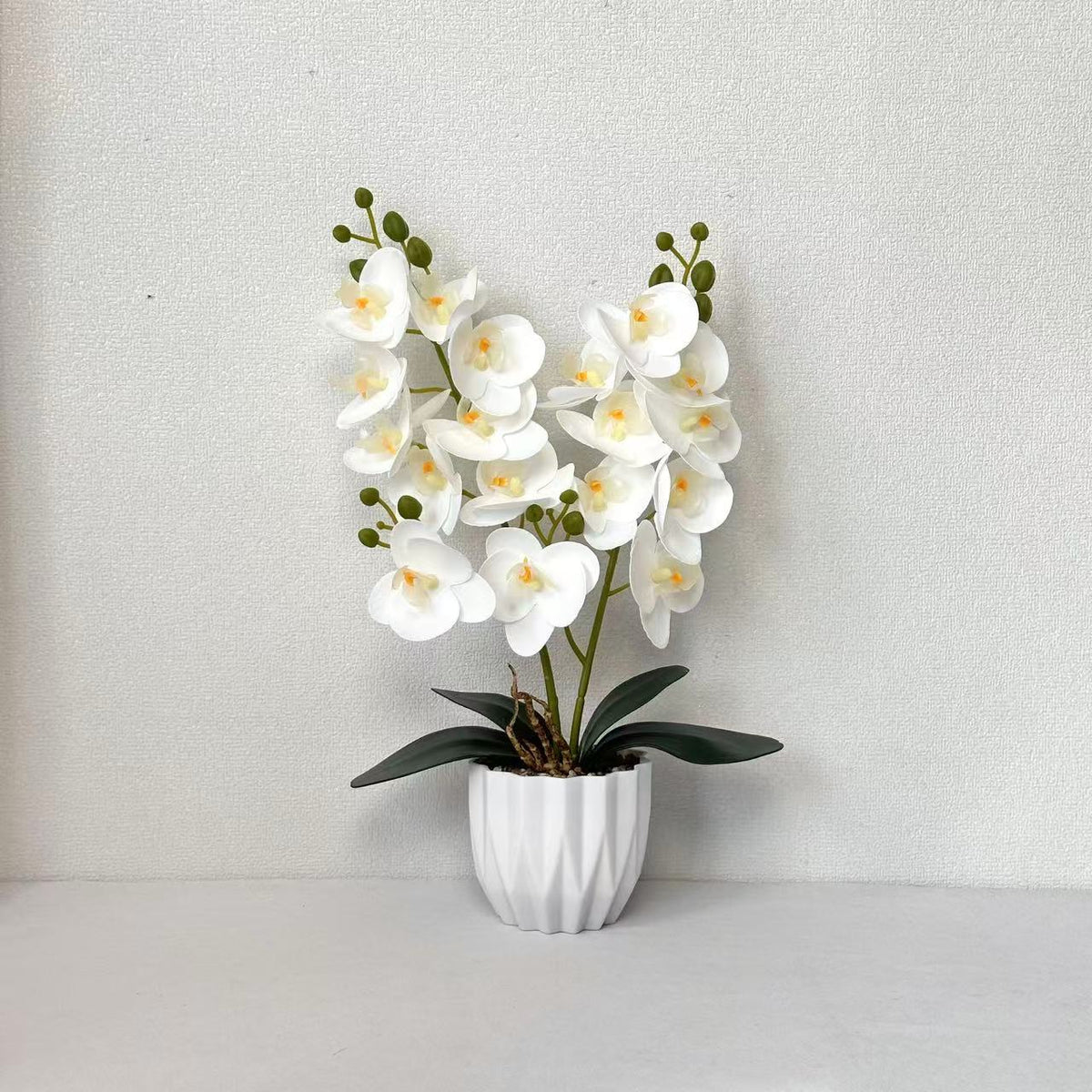 Dekoratives künstliches Orchideenarrangement für die Innendekoration zu Hause