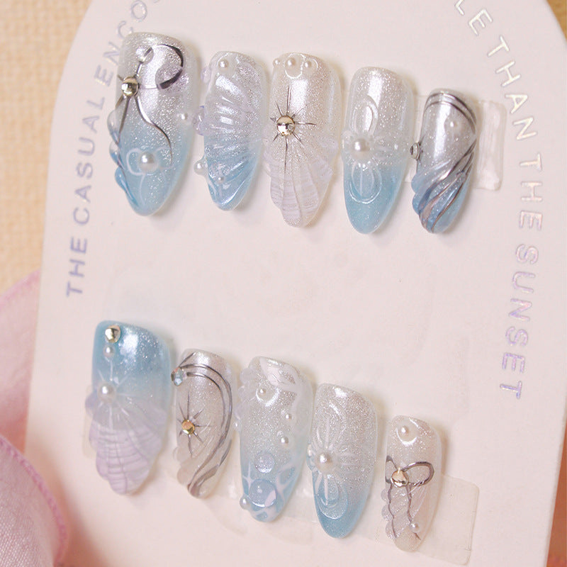 Kunstnagelset mit eleganten Muschel- und Perlenakzenten Brehn