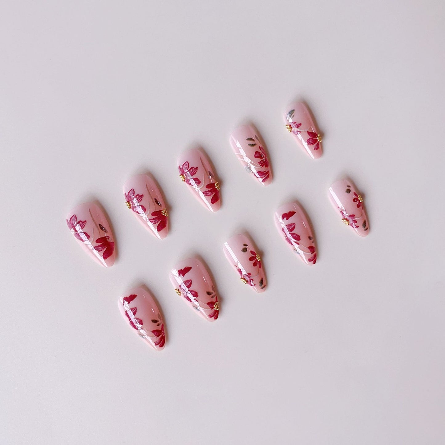 Kunstnagelset mit floralen Mustern und goldenen Akzenten Brehn