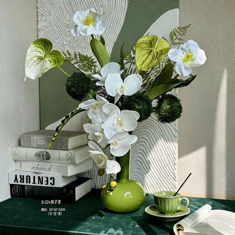 Künstliches Blumenarrangement mit dekorativer grüner Vase