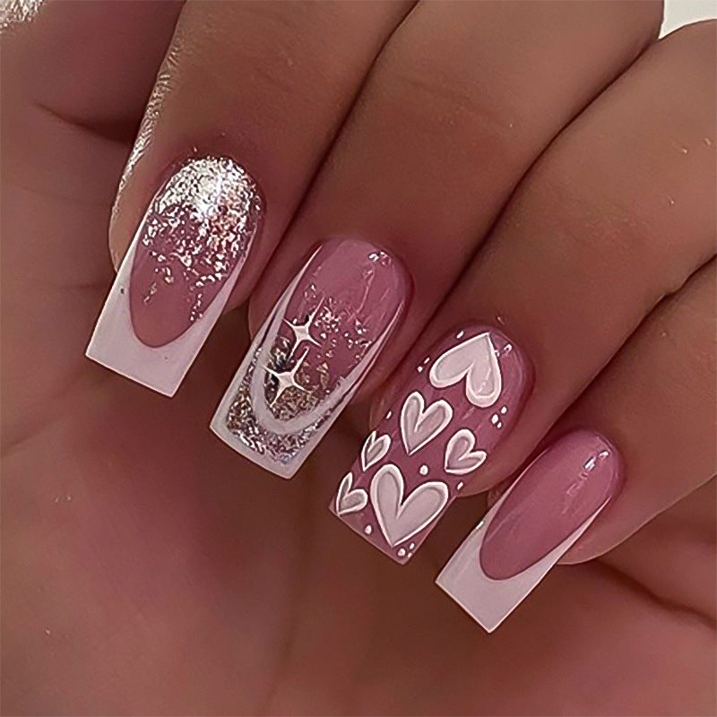 Kunstvolle Nagelverlängerungen mit modernem Glitzer-Design und Herzakzenten Brehn