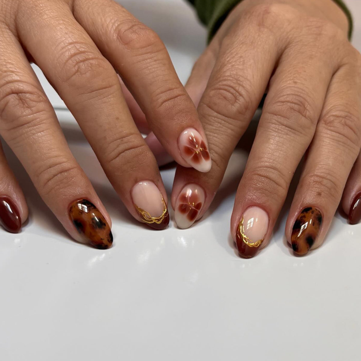 Kunstvolle Acryl-Nägel mit floralen Verzierungen und Glitzerakzenten Brehn