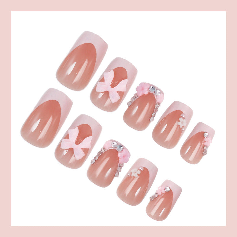 Kunstnagelset mit verspielten Schleifen und eleganten Blütenverzierungen Brehn