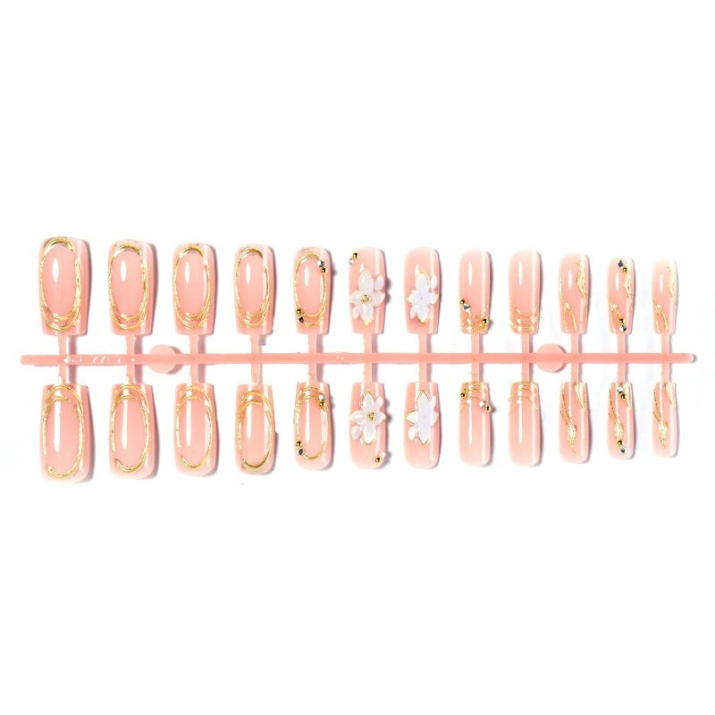 Elegantes Kunstnagelset mit dekorativen Blüten- und Goldverzierungen Brehn