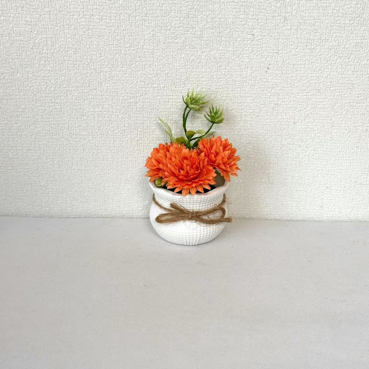 Dekorative Mini-Blumenarrangement im Topf