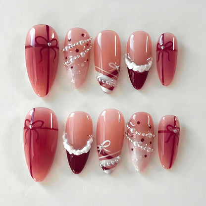 Kunstnagelset mit glamourösen Schleifen und eleganten Perlenverzierungen Brehn