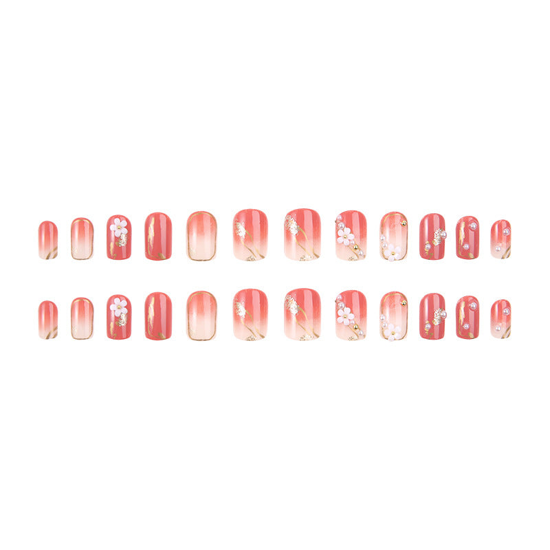 Kunstnagelset mit eleganten Blumendekoren und glamourösen Perlenakzenten Brehn
