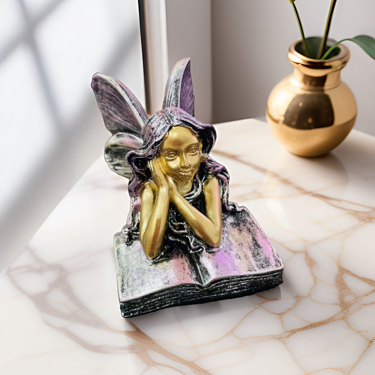 Feenfigurine, die auf Büchern sitzt, Brehn