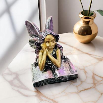 Feenfigurine, die auf Büchern sitzt, Brehn