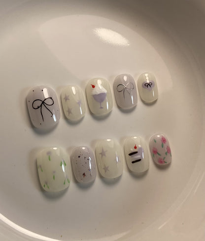Künstlerisches Press-On Nagelkunstkset mit niedlichen Kuchen- und Banddesigns